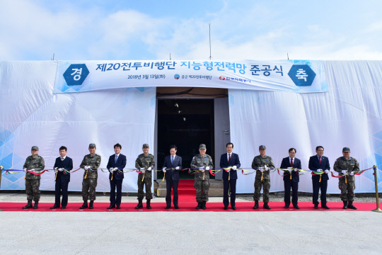 13일 충청남도 서산시에 있는 제20전투비행장에서 열린 한국전력 '지능형 전력망' 준공식에서 관계자들이 테이프 커팅을 하고 있다. 이 사업은 2024년까지 15개 공군 비행장의 노후 전력설비 지중화와 전압 단일화, 전력설비 제어시스템을 구축하는 한국전력 최초의 공익형 E&C(컨설팅·건설) 위탁사업이다. <한전 제공>